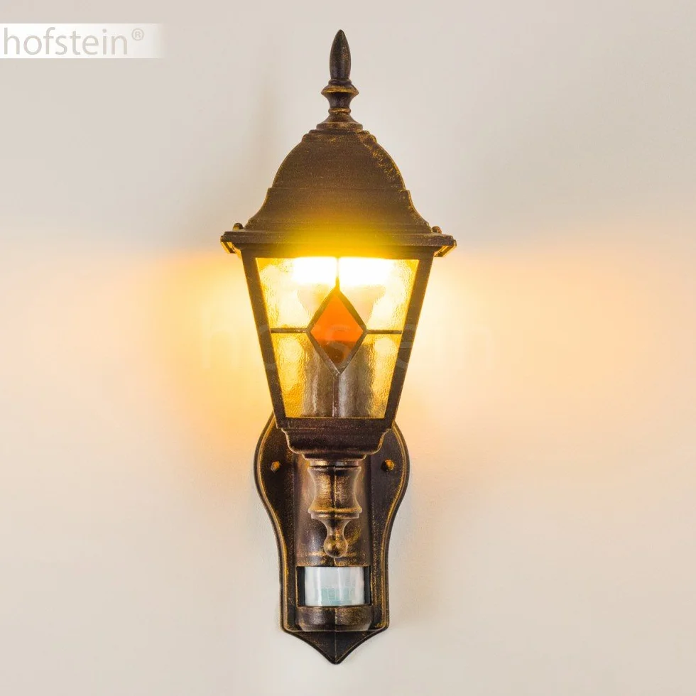 Zewnętrzna lampa ścienna Antibes z czujnikiem ruchu, z odlewu aluminiowego w kolorze brązowym/złotym z przezroczystymi szybami,/podwórko z oprawką E27 w kolorze antycznym, bez żarówek